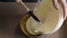 Kepėjas, pilantis vienalytę sūrio pyrago tešlą į pyrago formą