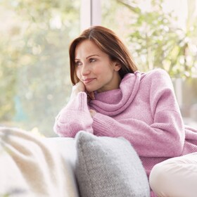 Moteris, besidžiaugianti savo vilnoniu megztiniu