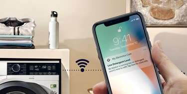 moteris žiūri į „My Electrolux“ programėlę mobiliajame telefone