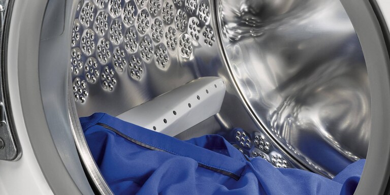 Paveikslėlyje parodytas tarpas, kurį reikia palikti tarp drabužių ir būgno viršaus