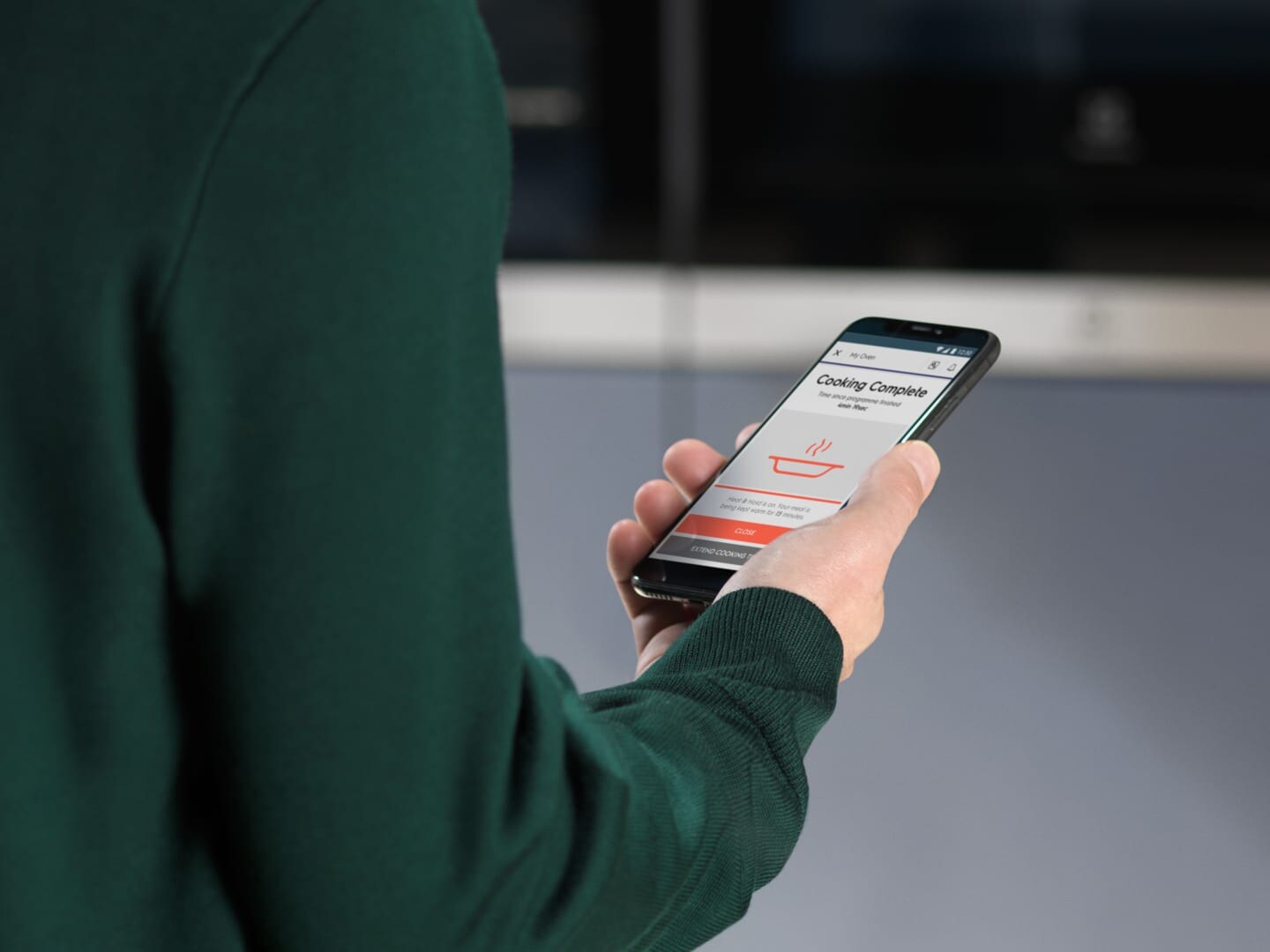 Žmogus, žiūrintis į mobiliąją programėlę telefone